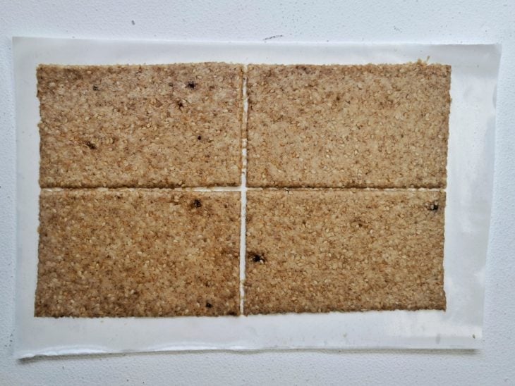 Massa aberta e cortada sobre uma folha de papel-manteiga.