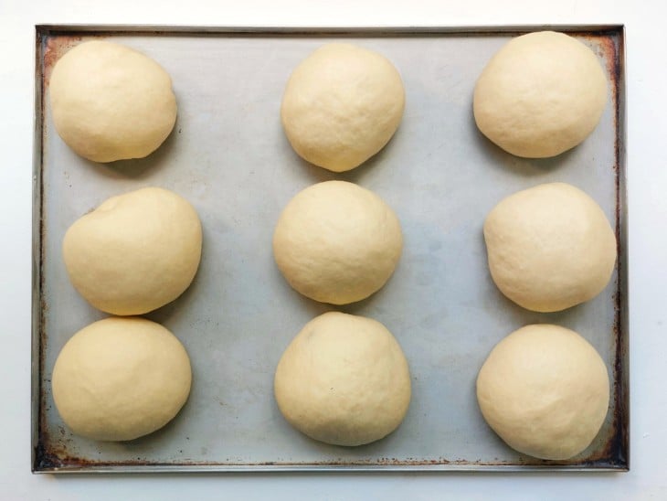 Uma forma contendo pãezinhos de cebola crus.