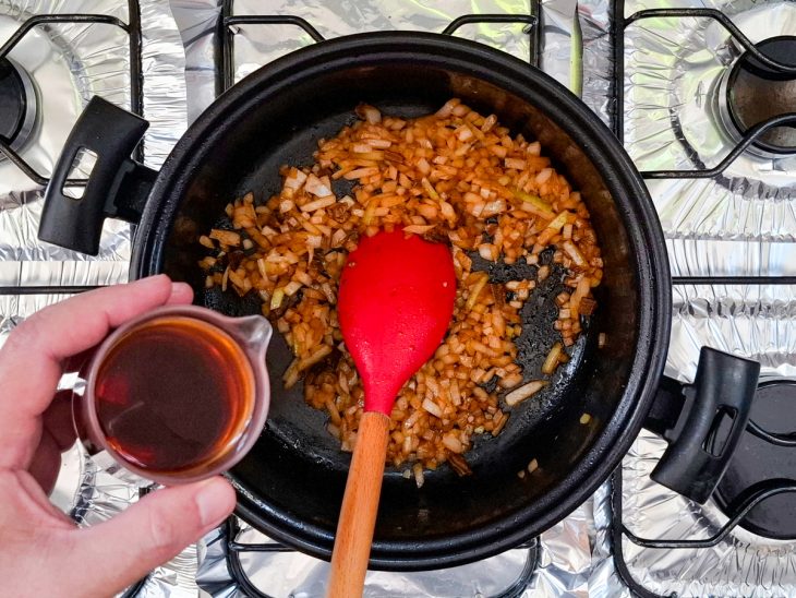 Na mesma panela, a cebola dourada, o funghi, e o caldo sendo adicionado.