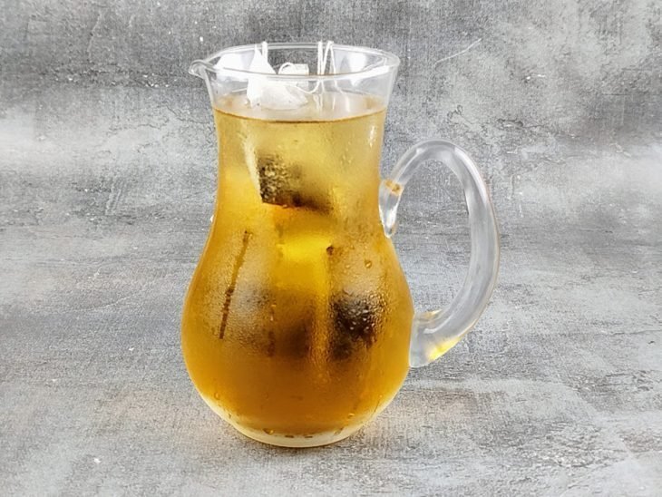 Sachês de chá infusionados na jarra com água.