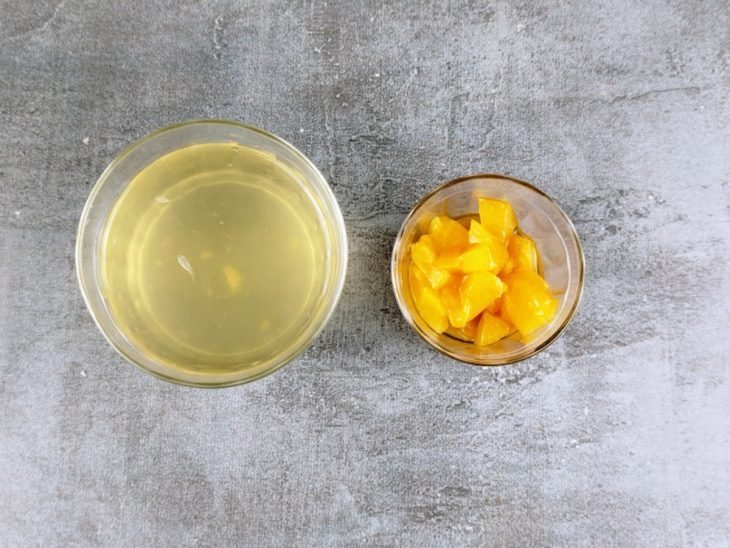 Pêssegos cortados em cubos e calda reservados.