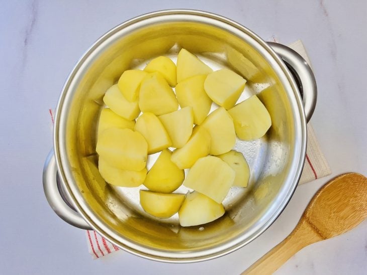 Uma panela contendo batatas cozidas.
