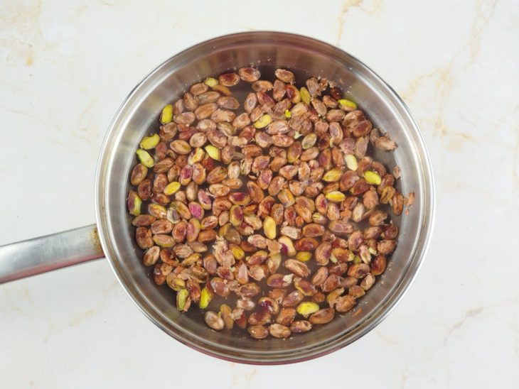 Pistaches organizados na bancada, alguns ainda com casca.