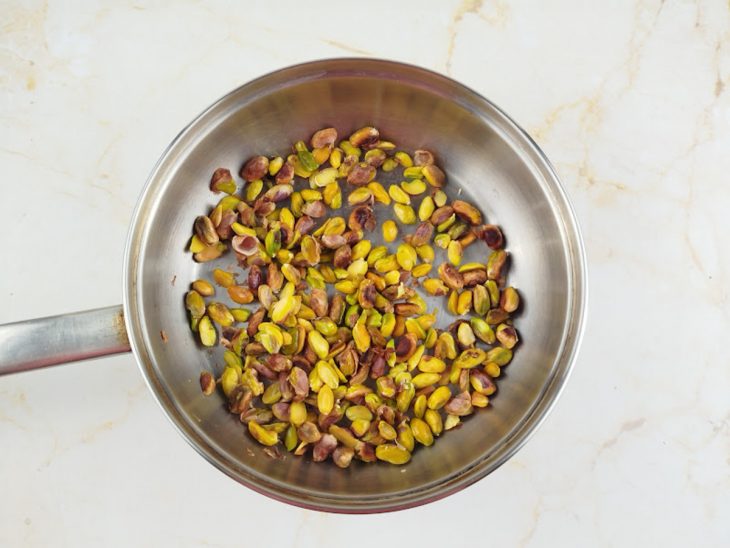 Pistaches sendo aquecidos levemente na frigideira.