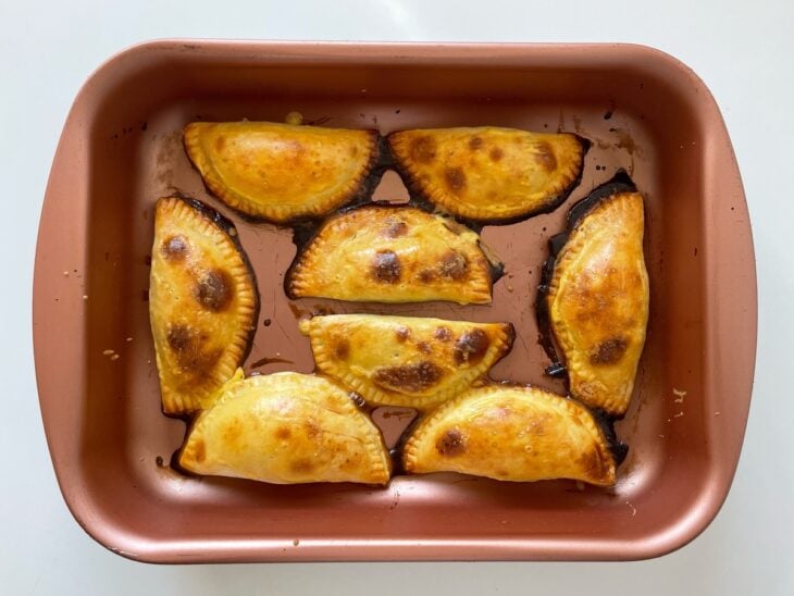 Pastéis assando até ficarem dourados e com aparência crocante.