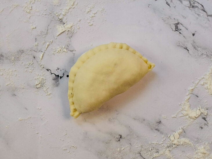 Pastel sendo fechado e cortado com aro redondo para acabamento uniforme.
