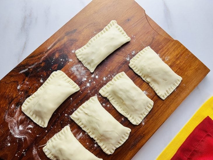 Pastéis crus sobre uma tábua.