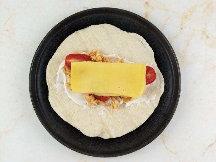 Fatia de queijo sobreposta aos tomates.