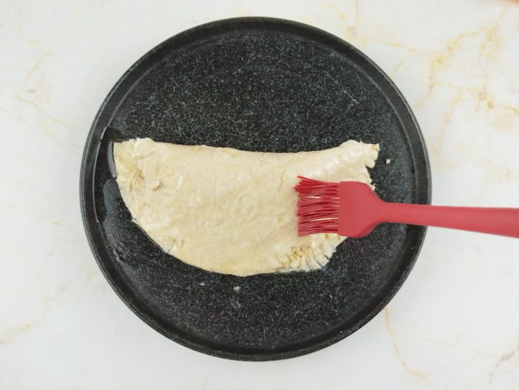 Pincel culinário com azeite na superfície do pastel.