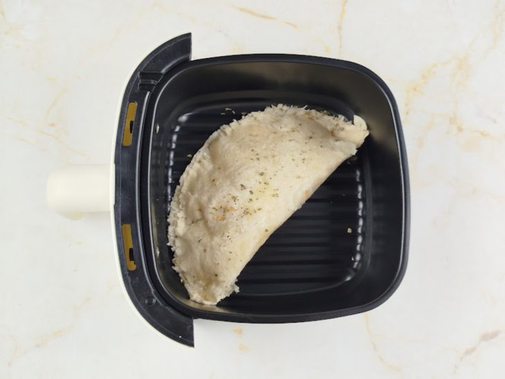 Pastel com wrap colocado no cesto da air fryer.