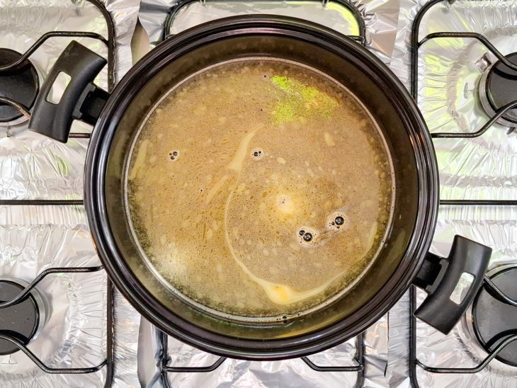 Água, sal e caldo de galinha na panela.