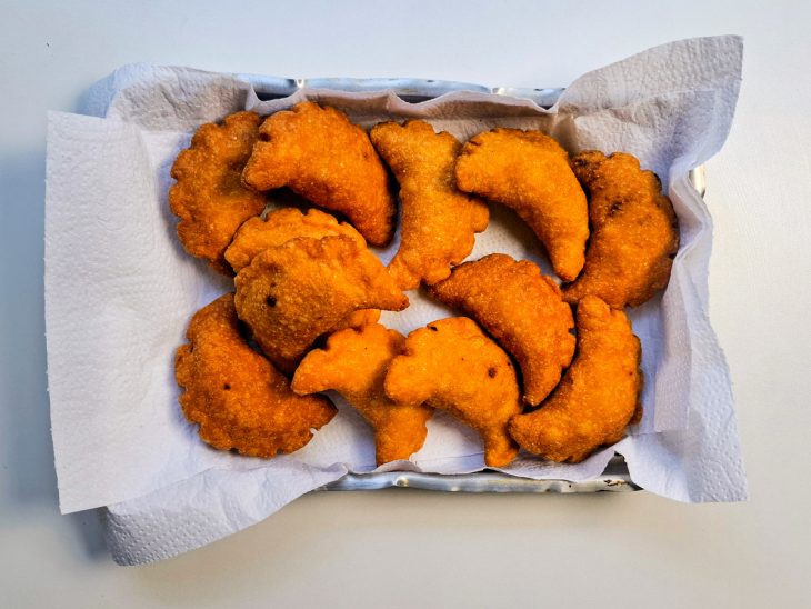 Pastéis fritos, descansando no papel toalha para escorrer o óleo.