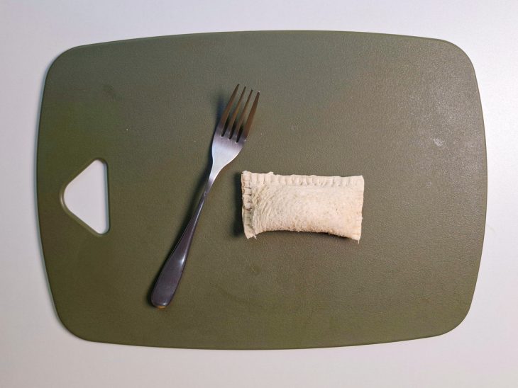 Pão dobrado ao meio com as bordas pressionadas com garfo.