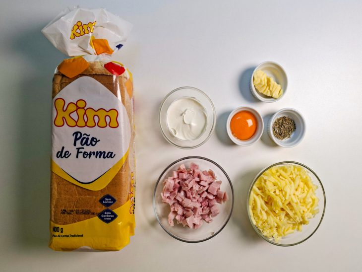 Ingredientes organizados na bancada com presunto e mussarela já picados.