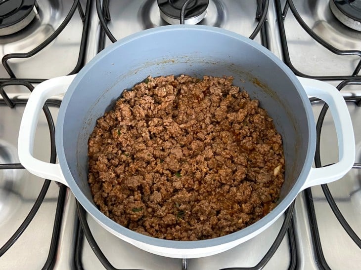 Uma panela contendo carne moída refogada com extrato de tomate.