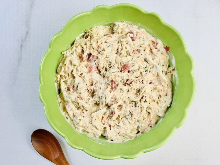 Maionese e creme de leite adicionados e incorporados na mistura de ingredientes da tigela.