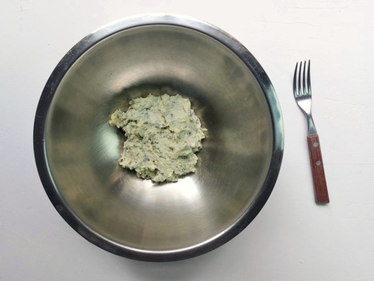 Um recipiente contendo gorgonzola amassado.