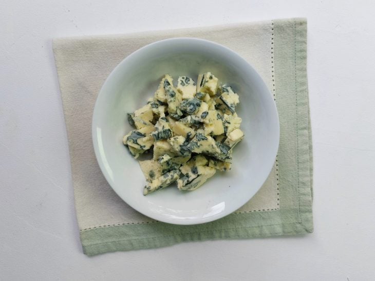 Um recipiente com gorgonzola picado.
