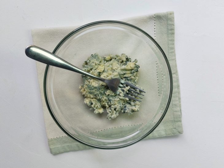 Um recipiente com gorgonzola amassado.