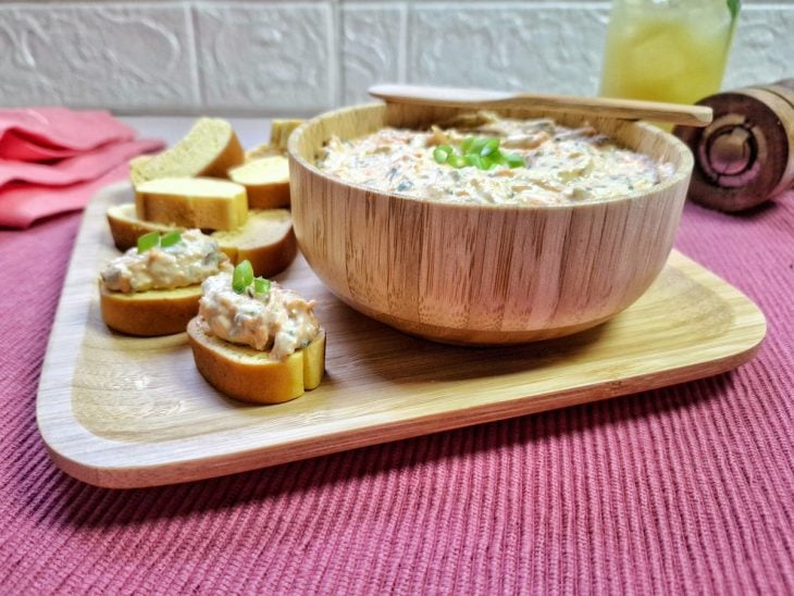 Pães e um bowl contendo patê de sardinha com cenoura.