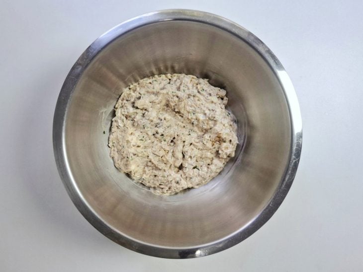 Ingredientes amassados e incorporados na tigela de inox redonda.