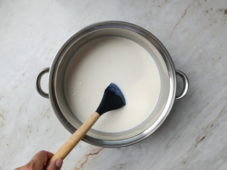 Ingredientes líquidos sendo misturados na panela com o fogo desligado.