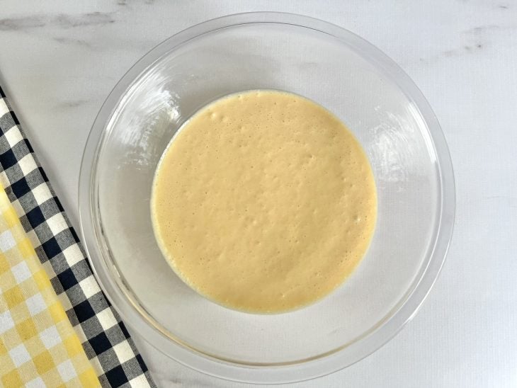 Um recipiente contendo a mistura de manteiga, gemas, açúcar e creme de leite.