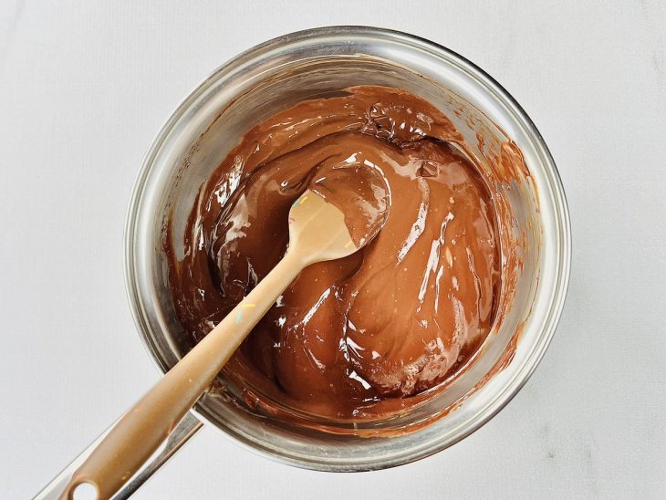 Chocolate meio-amargo e creme de leite misturados em uma panela.