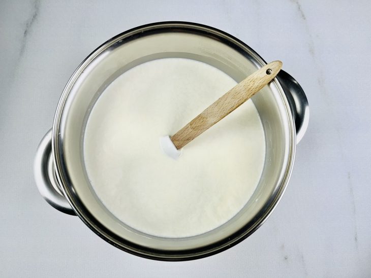 Na panela, o leite e o creme de leite adicionados.