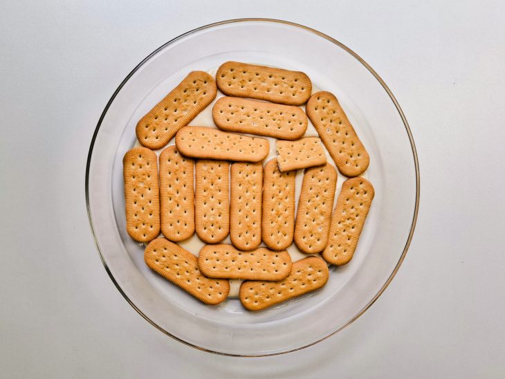 Na travessa, uma camada de biscoitos no fundo.