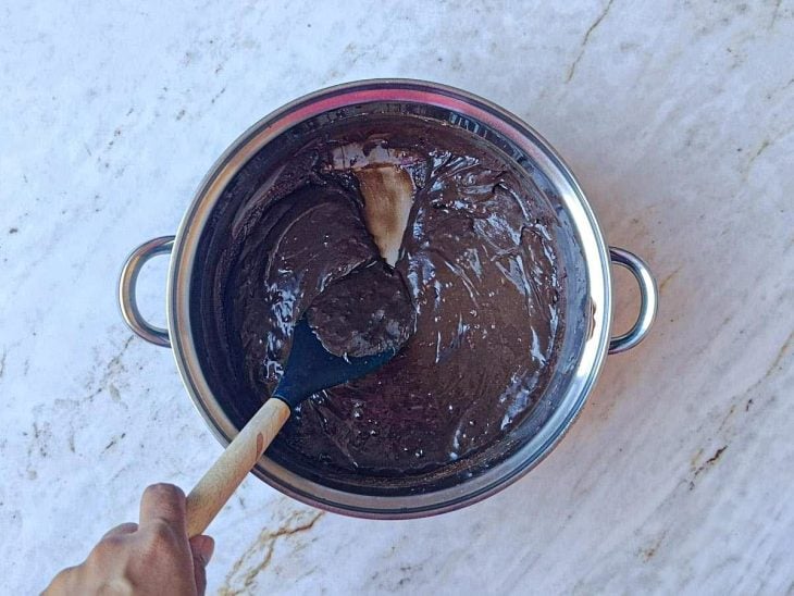 Leite condensado, chocolate e manteiga sendo levados ao fogo na panela.