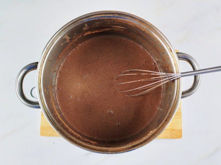 Uma panela com amido, leite, chocolate em pó e o leite condensado.