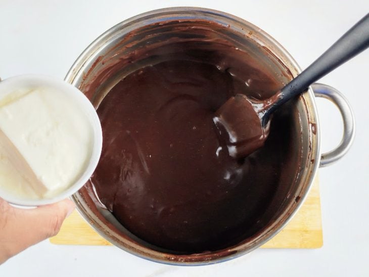 Creme de leite sendo adicionado à panela com creme de chocolate.