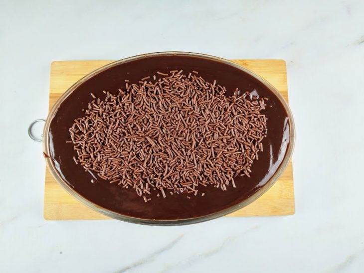 Uma travessa contendo pavê de chocolate com bolacha maisena.
