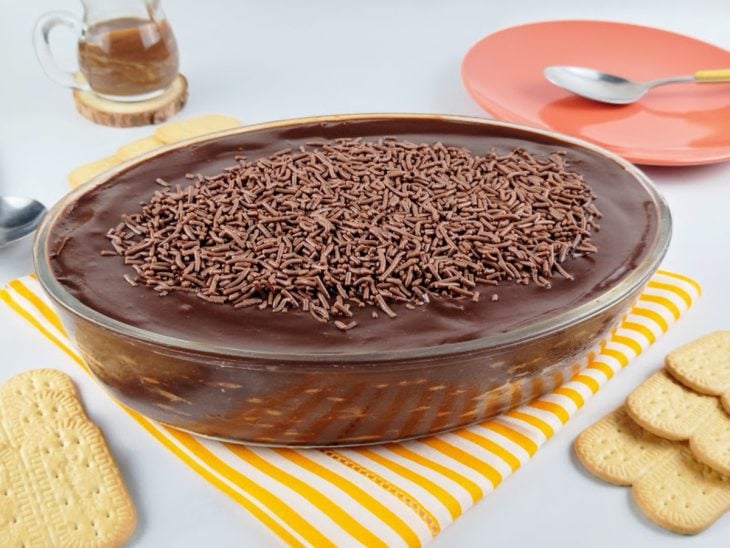 Uma travessa contendo pavê de chocolate com bolacha maisena.