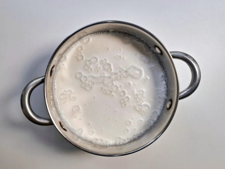 Uma panela com leite, amido, leite condensado e creme de leite.