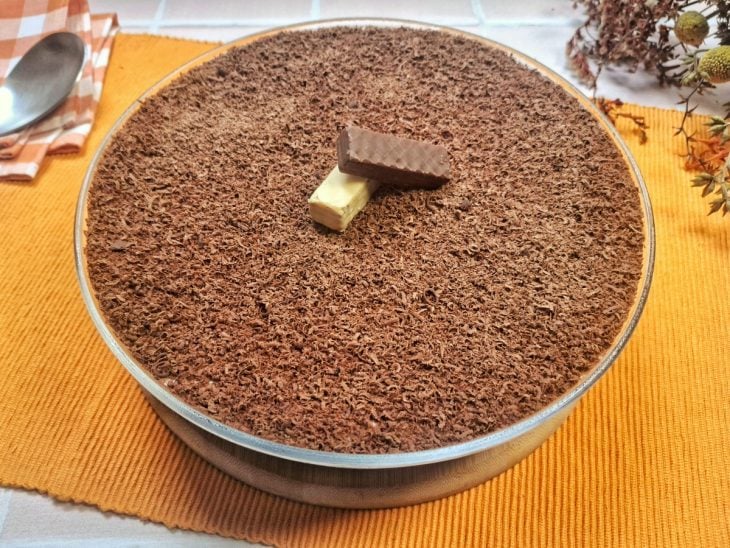 Um refratário com pavê de chocolate com creme branco.