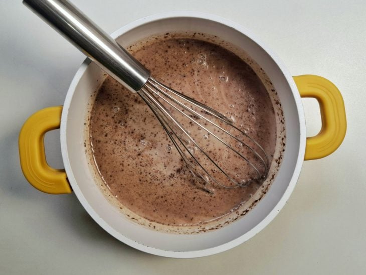 Uma panela com leite condensado, chocolate em pó, amido de milho e creme de leite.
