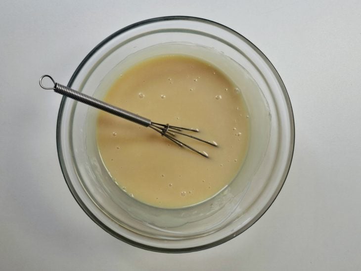 Uma tigela com ganache de chocolate branco.