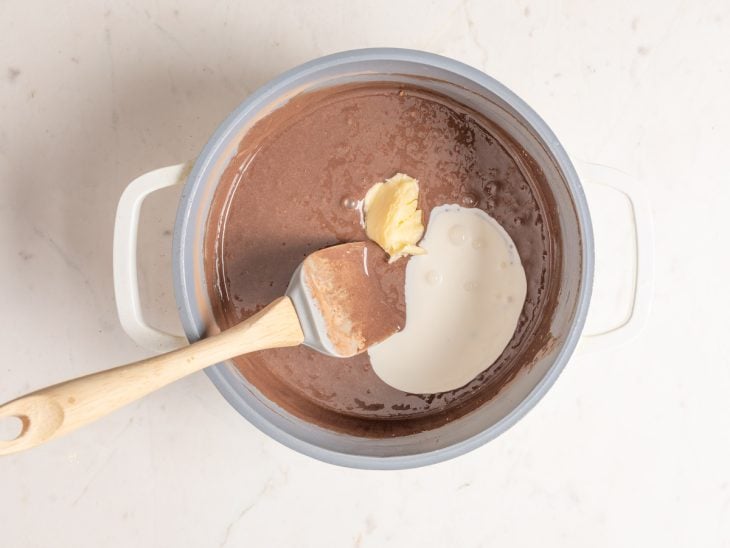 Ingredientes adicionados na panela em fogo médio para preparar o creme de chocolate.