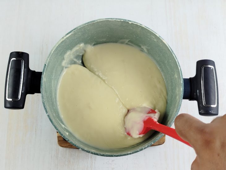 Na panela, o leite condensado, o creme de leite, o leite e o amido de milho.
