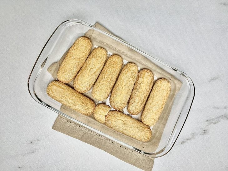 Travessa com uma camada de bolachas champagne.
