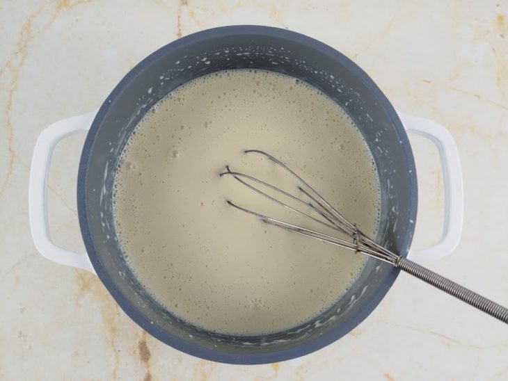 Ingredientes líquidos misturados com o amido e o leite em pó na panela.