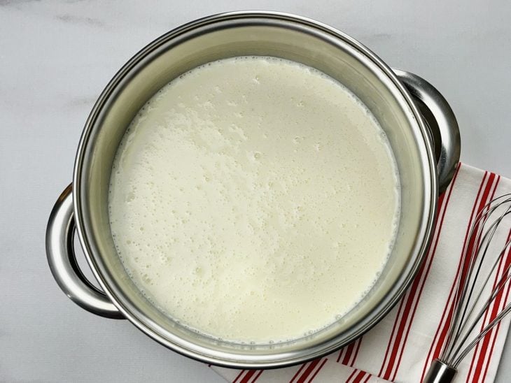 Uma panela com leite condensado, amido de milho, leite integral, creme de leite e leite em pó.