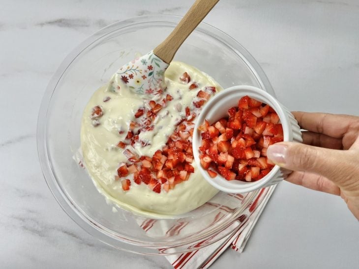 Uma tigela com a mistura de creme e morango.