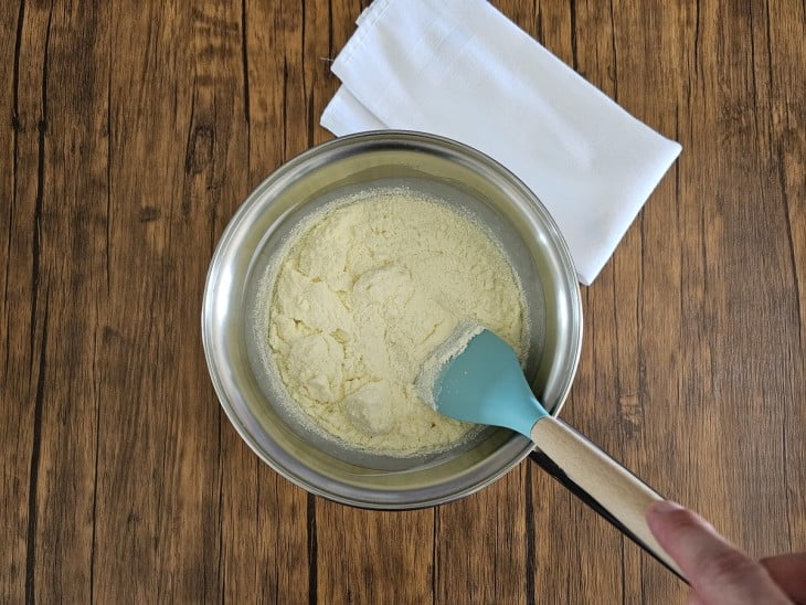 Uma panela com leite condensado, o amido de milho, creme de leite e leite Ninho.