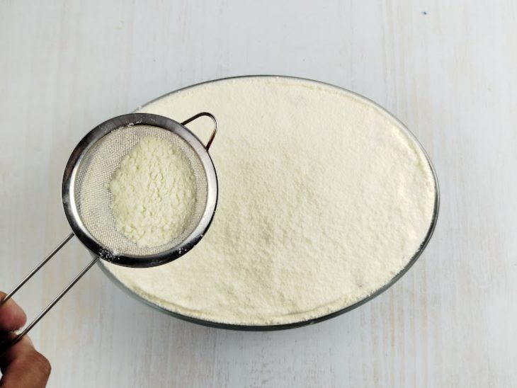 Leite em pó peneirado sobre a superfície.