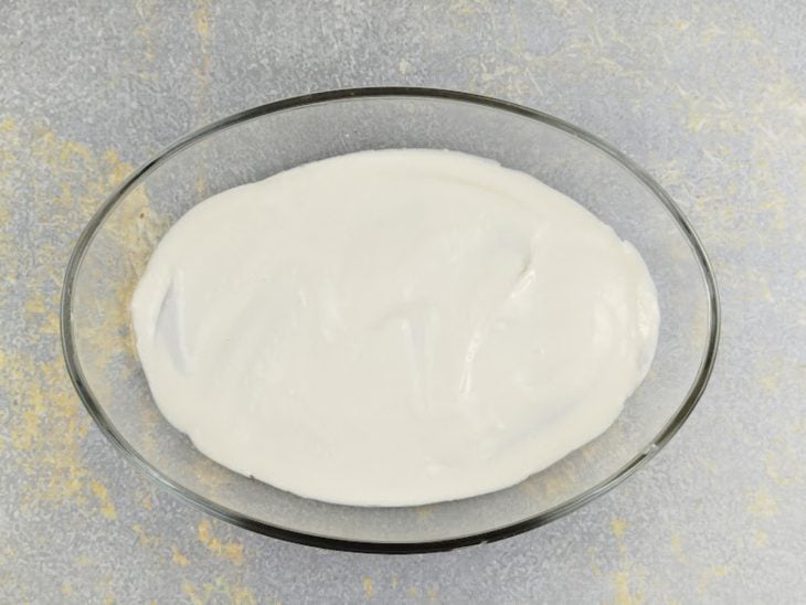 Creme sendo colocado na travessa.