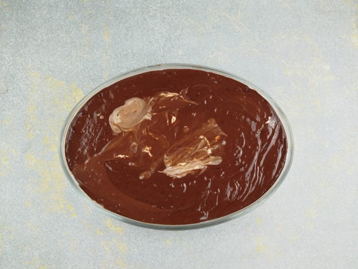 Ganache sendo espalhada sobre o pavê.