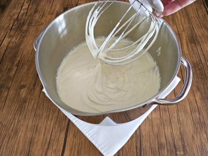 Uma batedeira com a mistura de nata e leite condensado.